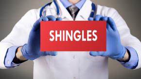 Hands holding shingles sign