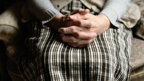 older woman with clasped hands