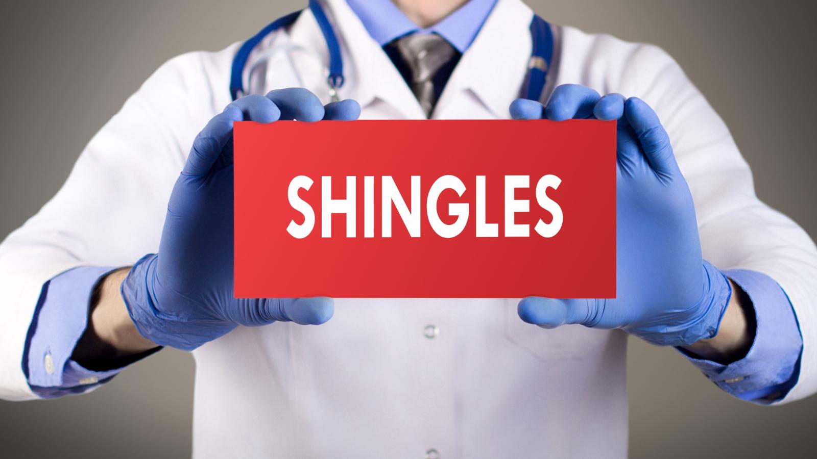 Hands holding shingles sign