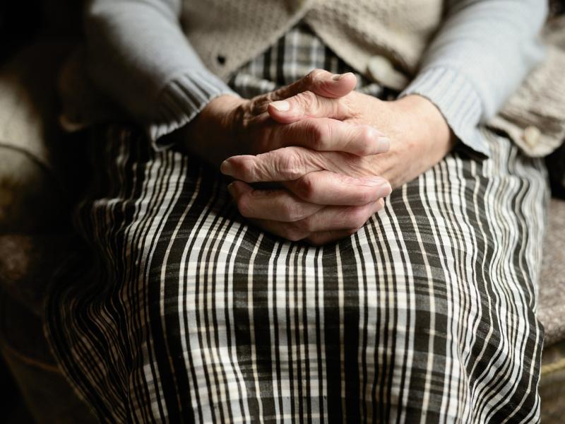 older woman with clasped hands